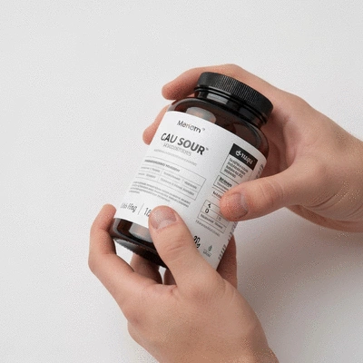 Person reading a product label on a supplement bottle